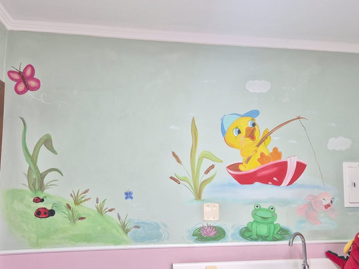 Mural pintado à mão: patinho de boné pescando em um barquinho vermelho, com sapo, peixe e joaninhas na grama.